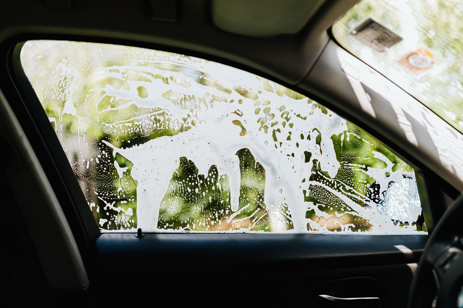 Illustration of a car window being worked on with soapy solution